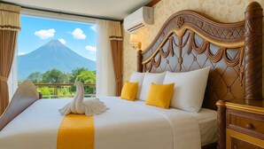 A hotel room with a bed, a swan decoration, and a view of a mountain. - Royal Caravan Hotel Trawas (Trawas)
