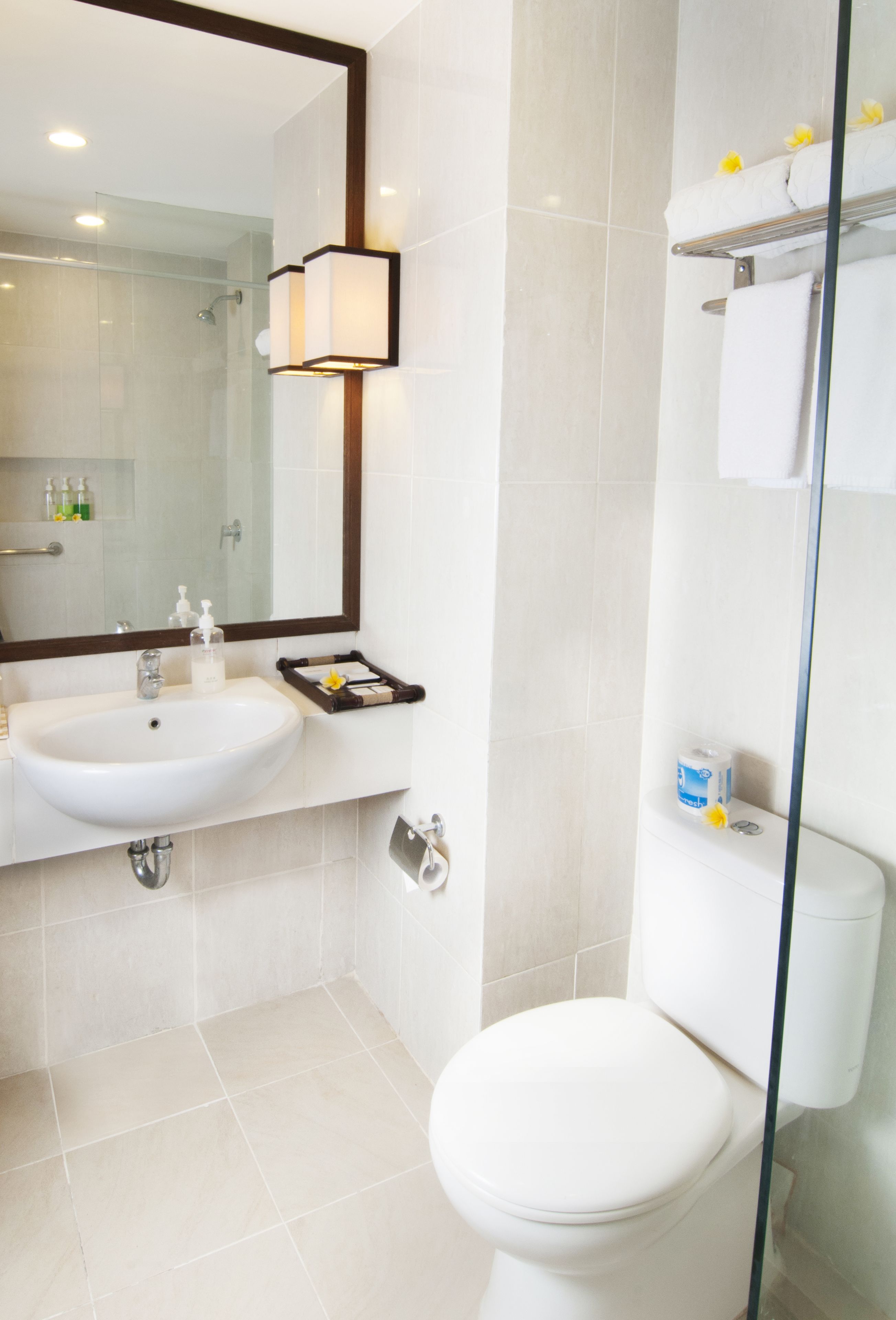 A bathroom with a white sink, mirror, and toilet.