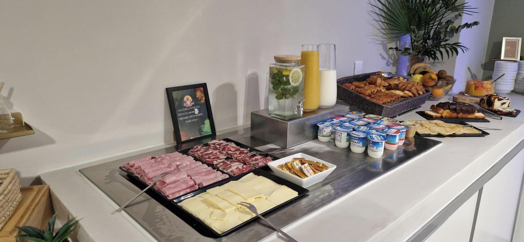 A buffet with various food items including meats, cheeses, and pastries.