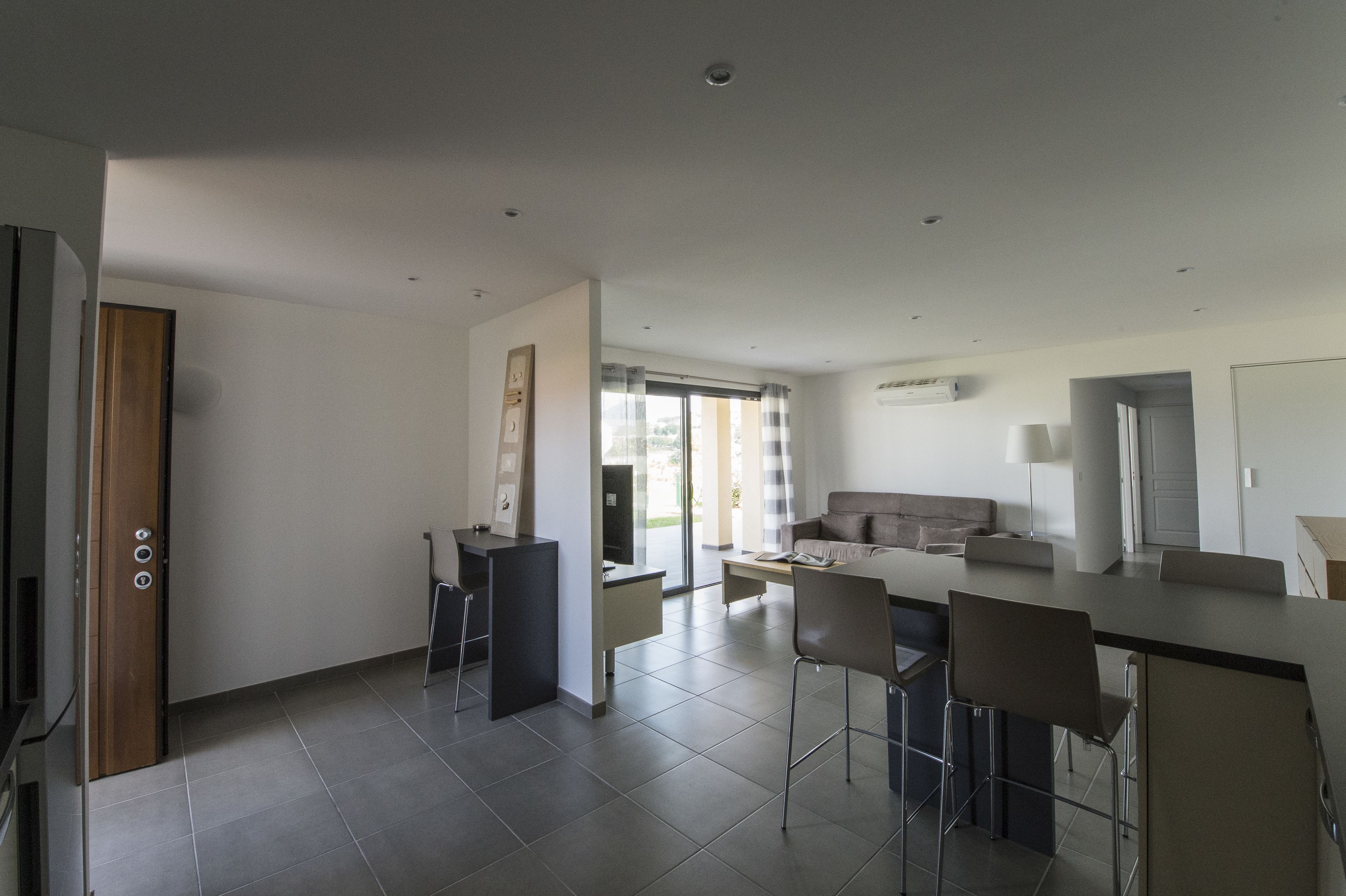 Una cocina moderna con comedor, sofá y televisor.
