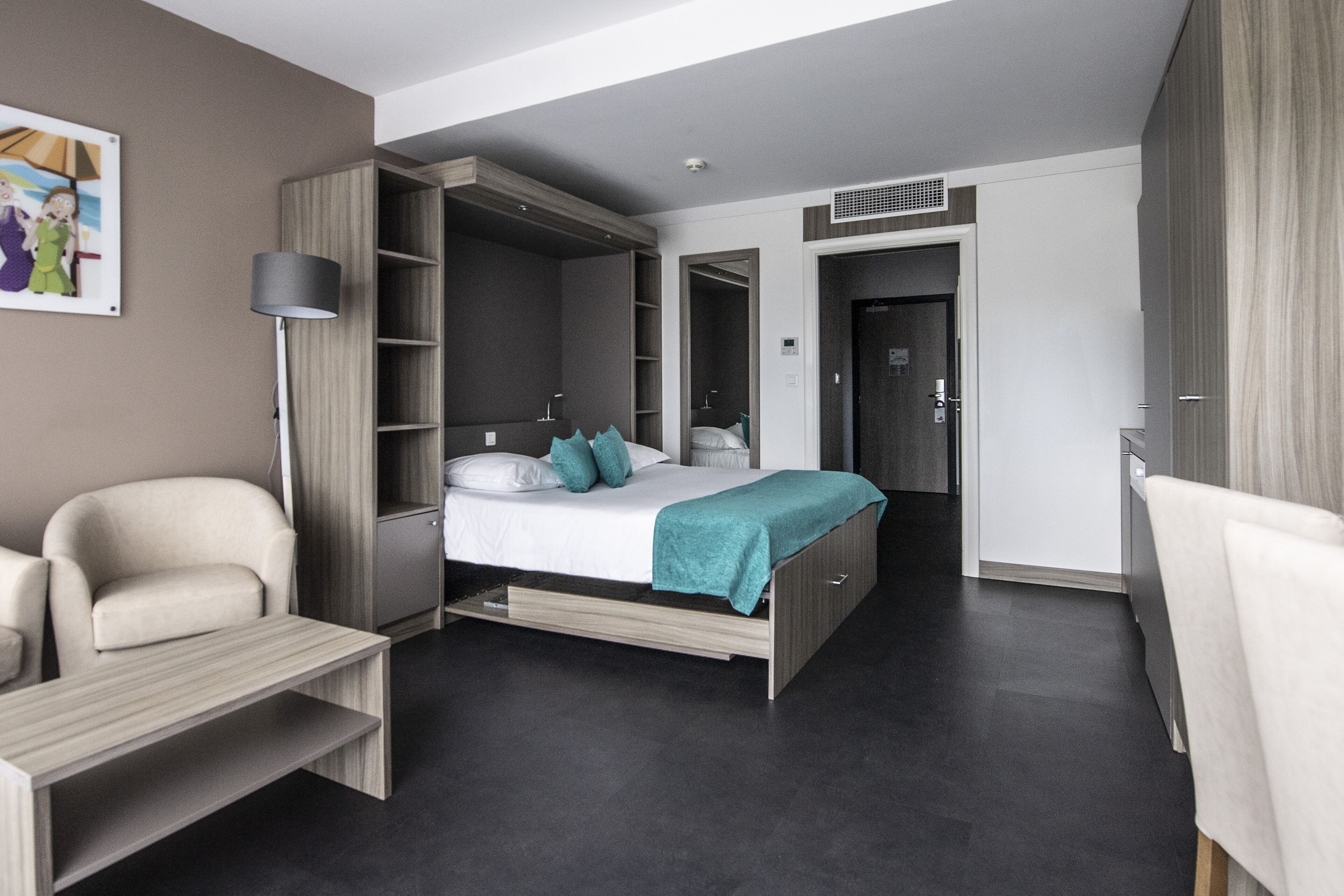 A modern bedroom with a bed, a desk, a chair, and a wardrobe.