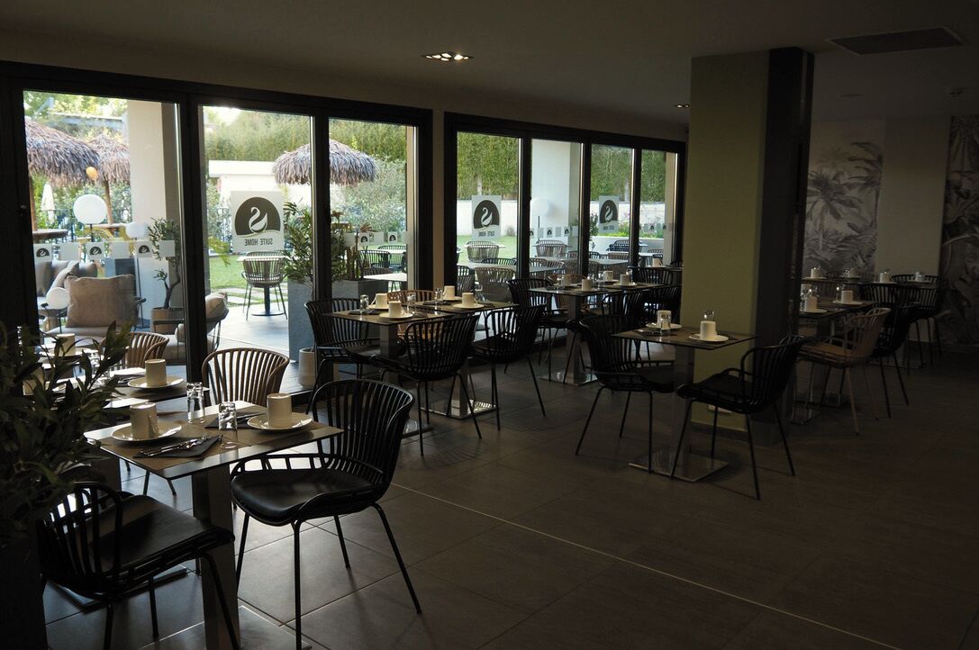 Un restaurant doté d’une terrasse, de grandes fenêtres et d’un décor intérieur moderne.