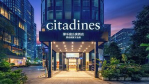 Een modern gebouw met een opvallend ‘Citadines’-bord, met een glazen entree en een goed verlichte gevel.