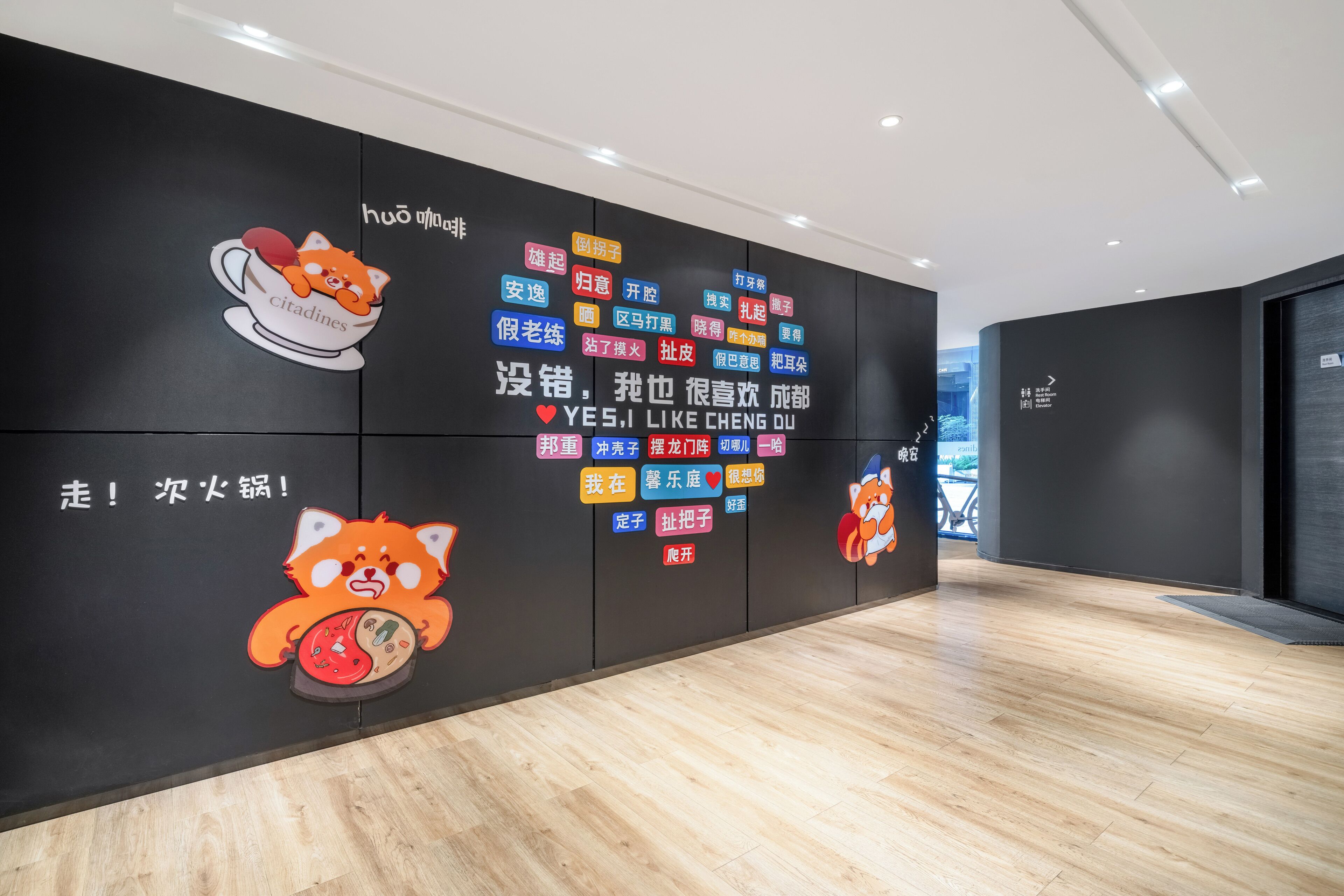 A modern interior with a black wall featuring colorful text and cartoon characters.
