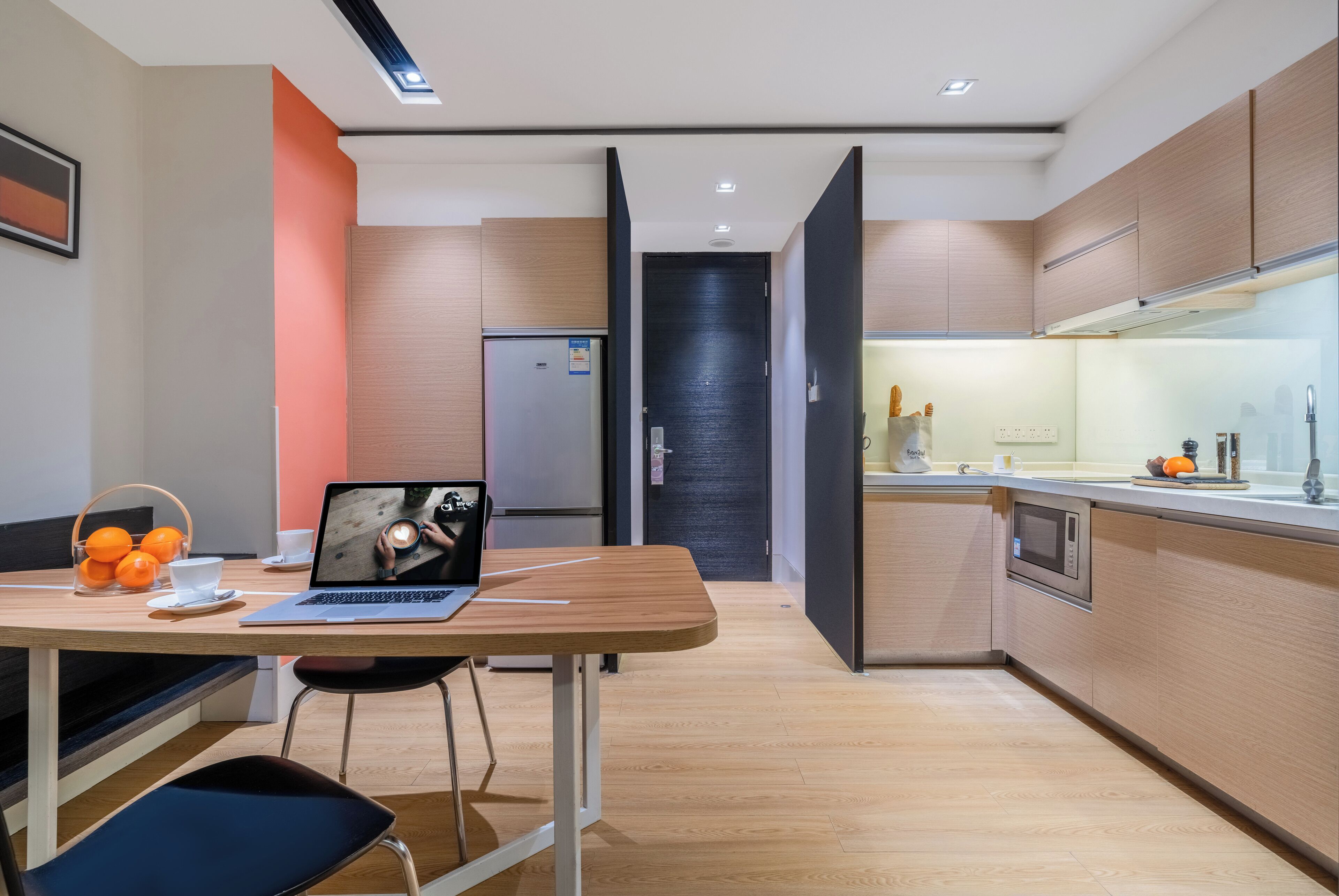 A modern kitchen with wooden cabinets, a built-in microwave, and a countertop with a sink.