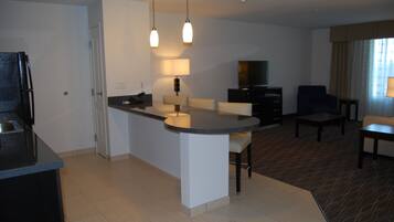 Habitación de hotel moderna con cocina, una mesa de comedor y zona de estar.