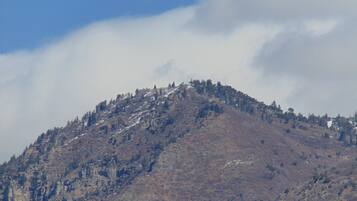 Una montaña con vegetación escasa y cielo despejado.