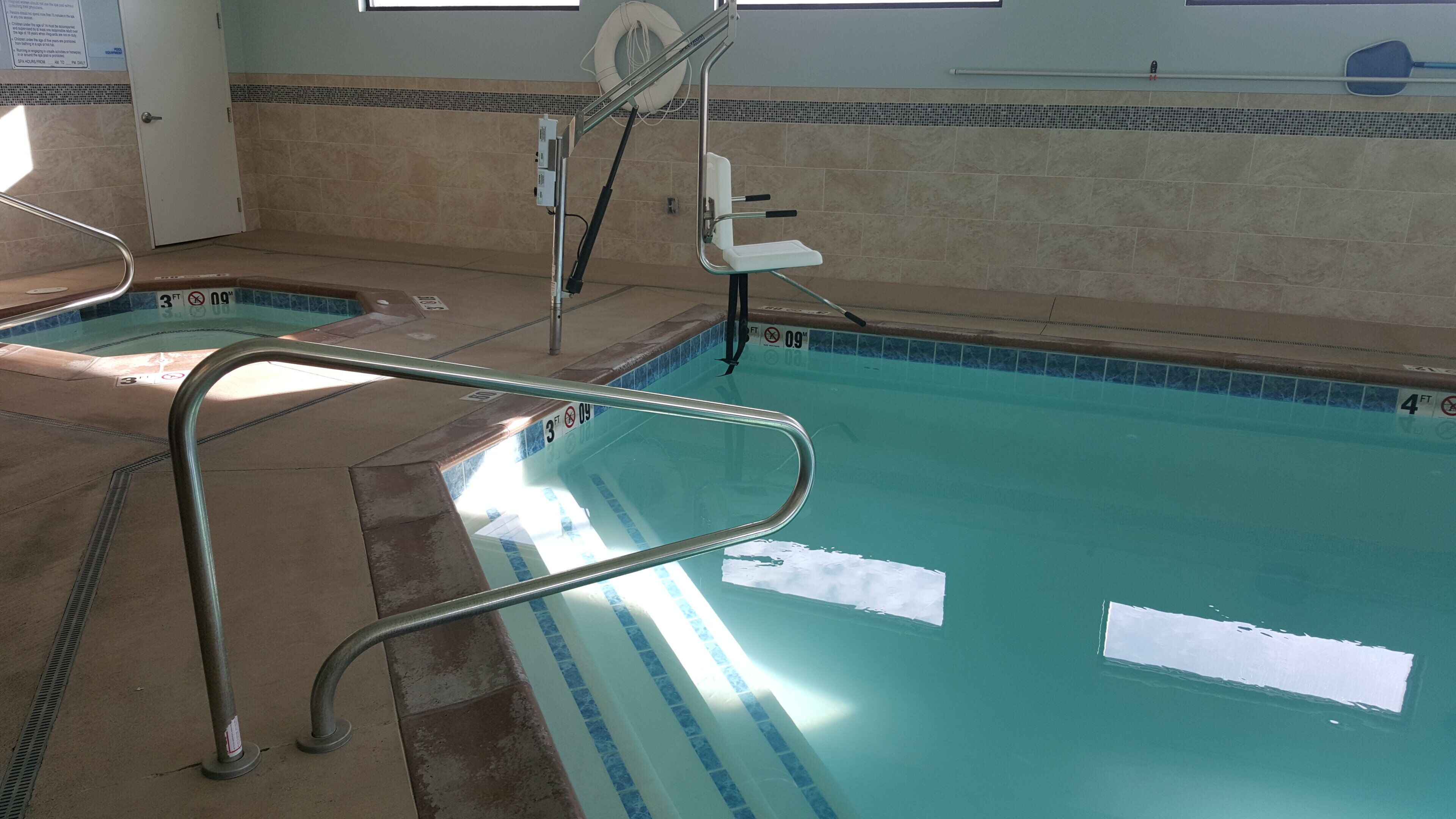 A swimming pool with a diving board and a lifeguard chair.