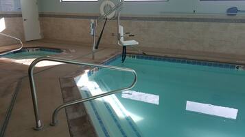 A swimming pool with a diving board and a lifeguard chair.