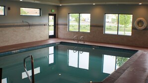 An indoor swimming pool with clear glass walls, a lifeguard chair, and windows with views of the outdoors. - Holiday Inn Express & Suites Springville-South Provo Area by IHG (Springville)