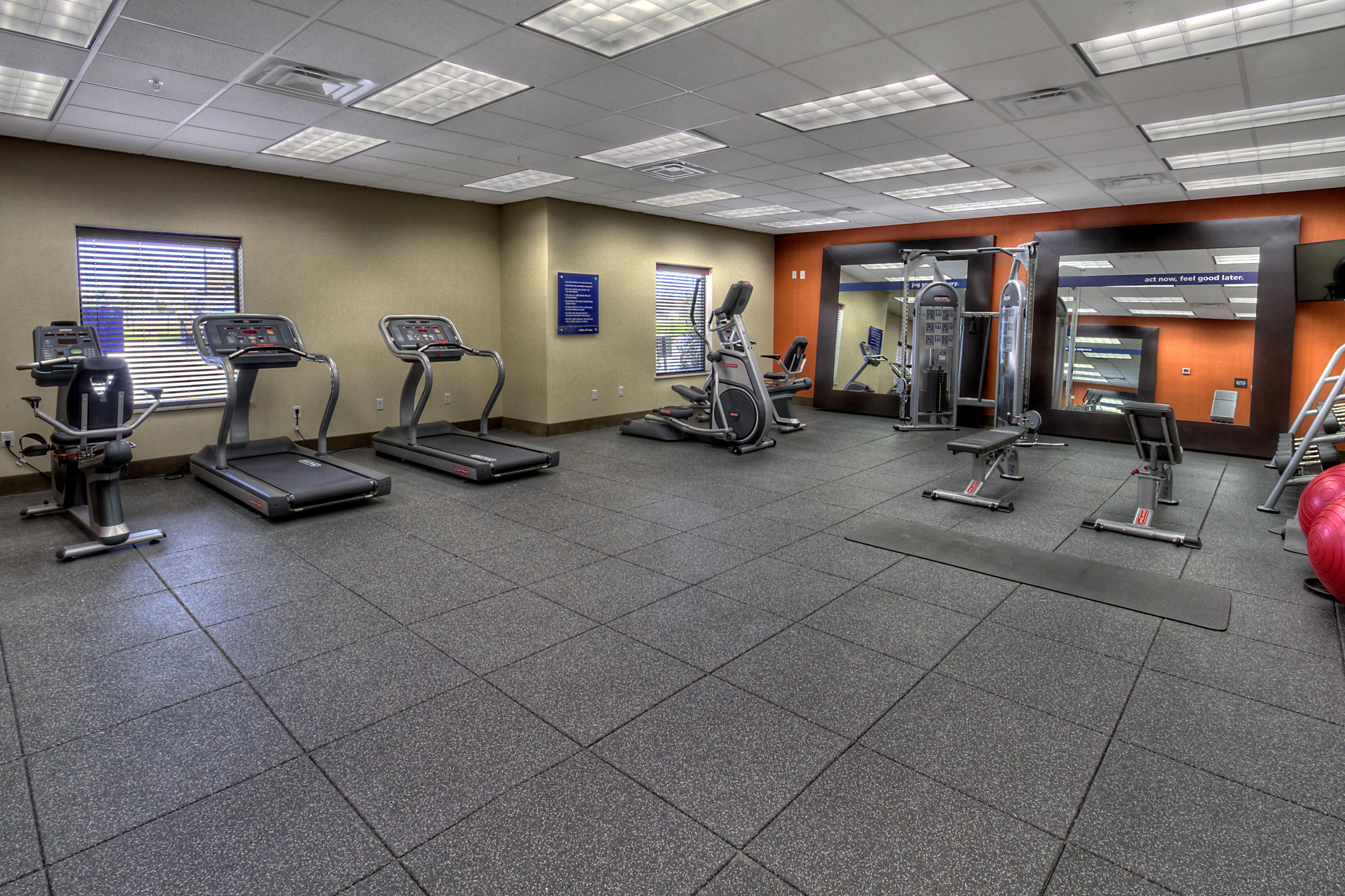 A gym with treadmills, elliptical machines, and weight equipment.