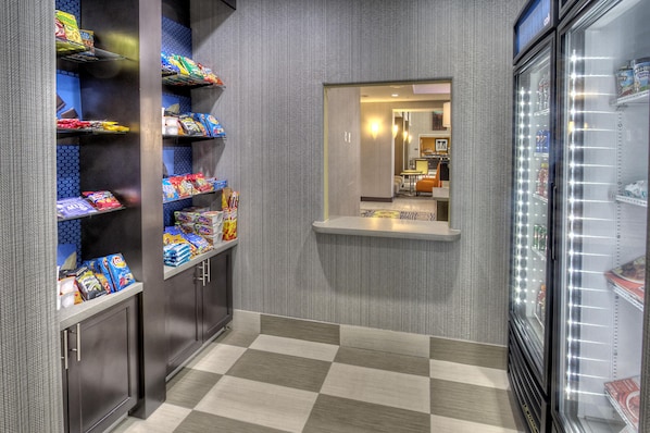 A corridor with snack shelves and a refrigerator. - Hampton Inn & Suites Ada (Ada)