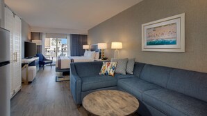 Une chambre d’hôtel moderne équipée d’un grand lit, d’un canapé, d’une télévision et d’une table à manger.