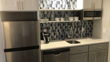 A modern kitchen with stainless steel appliances, a dishwasher, and a microwave.