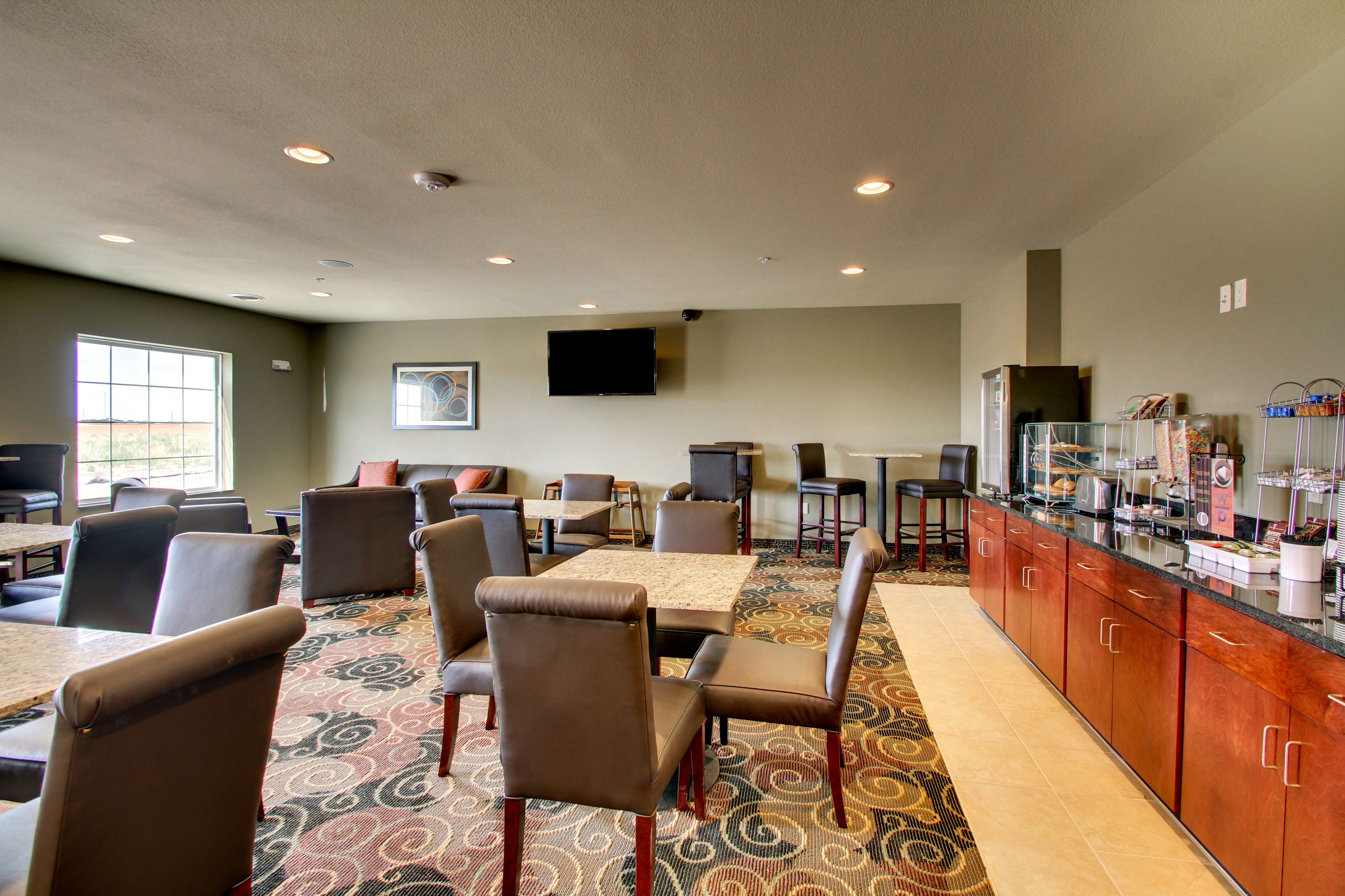 A restaurant with booths and tables, a flat-screen TV, and a buffet area with various food items.