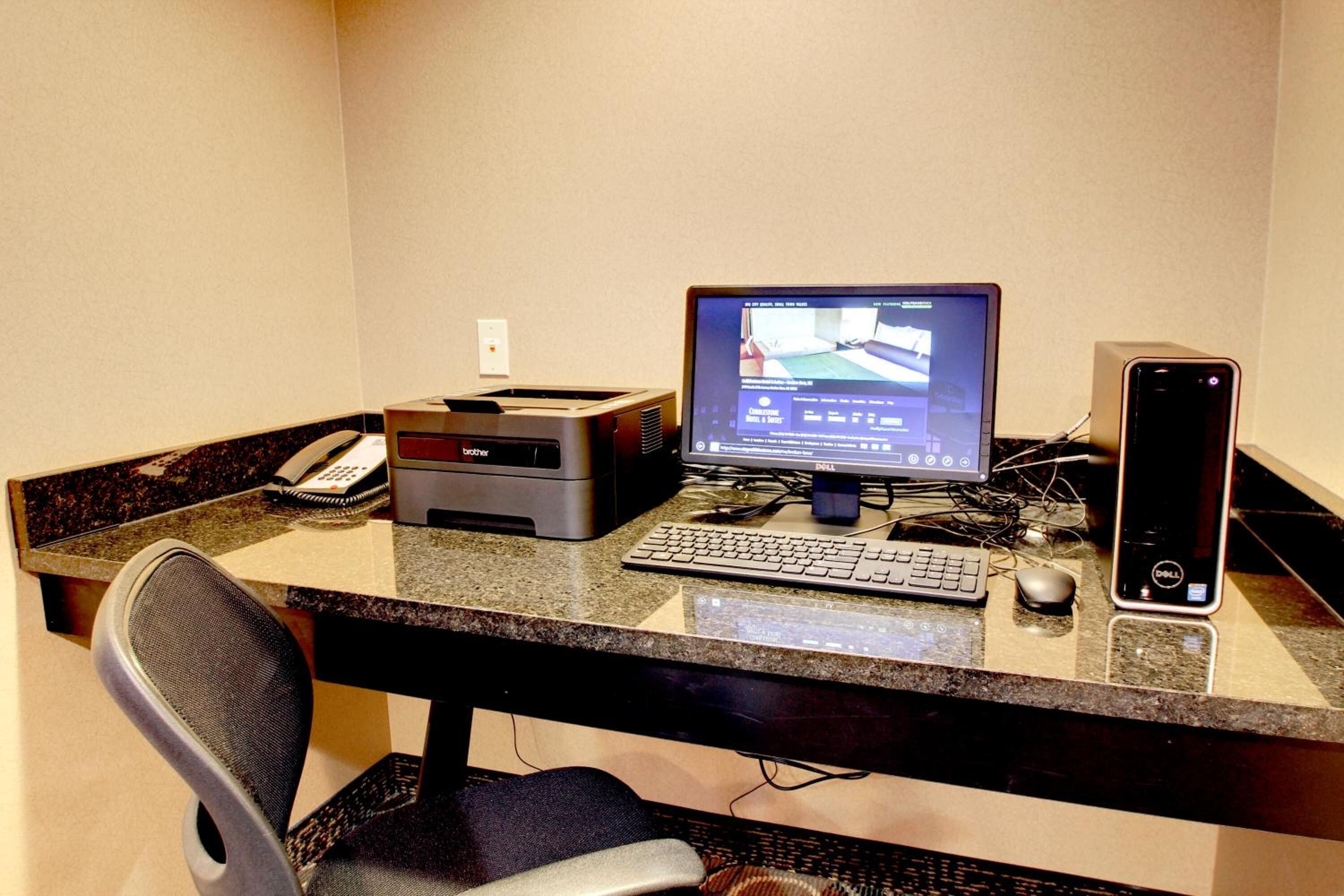 A desk with a computer, keyboard, mouse, and printer.