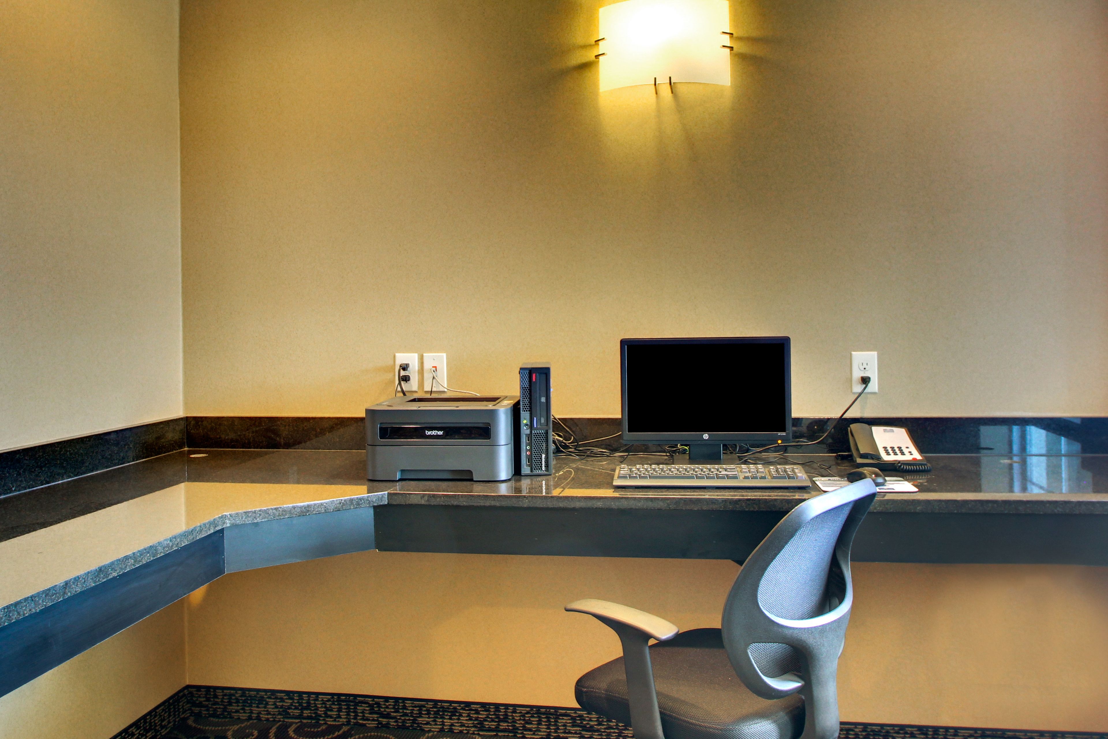 Una recepción de hotel con computadora, impresora y teléfono.