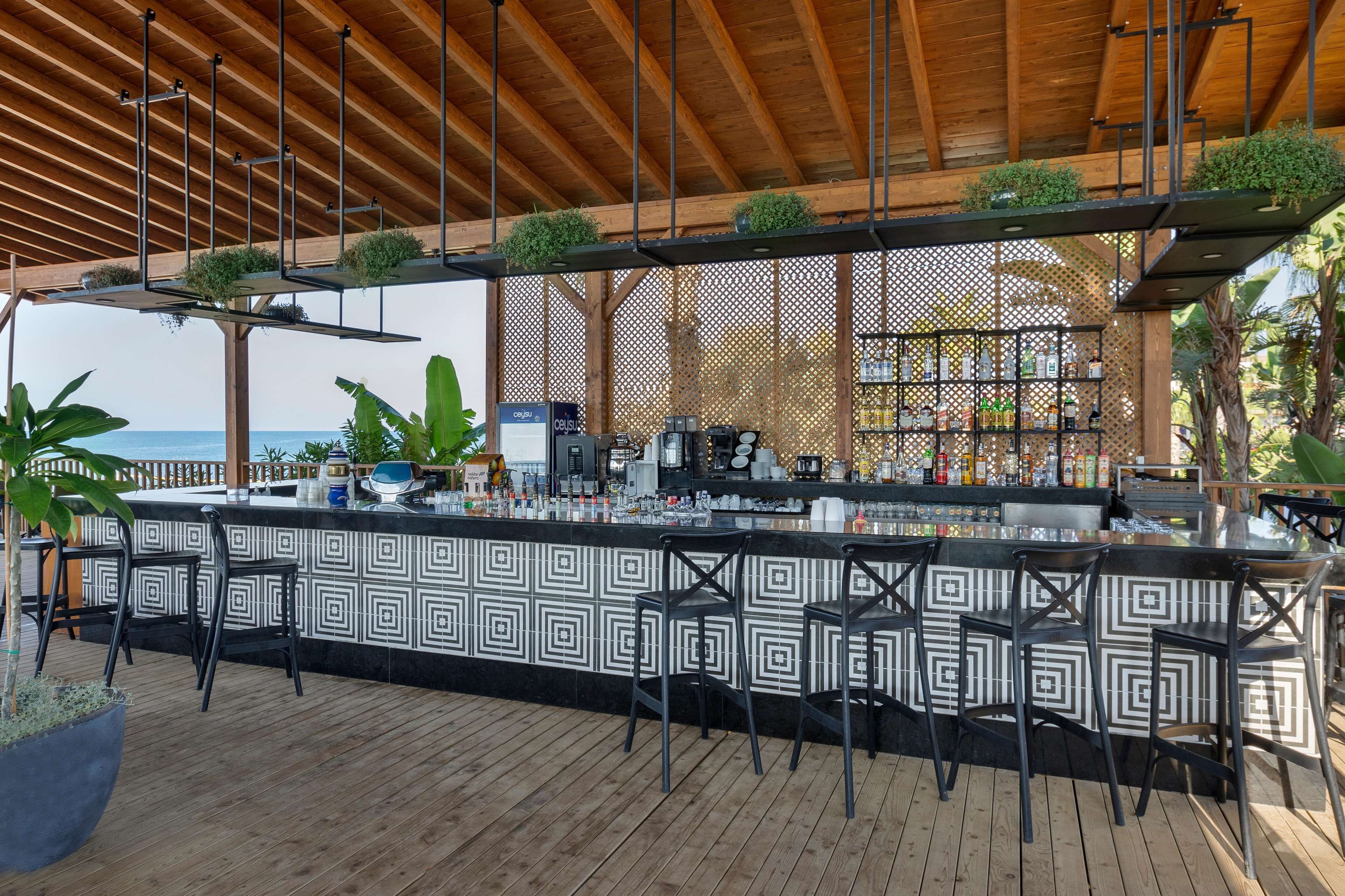 Angolo bar con schienale decorato, soffitto in legno e sgabelli da bar.