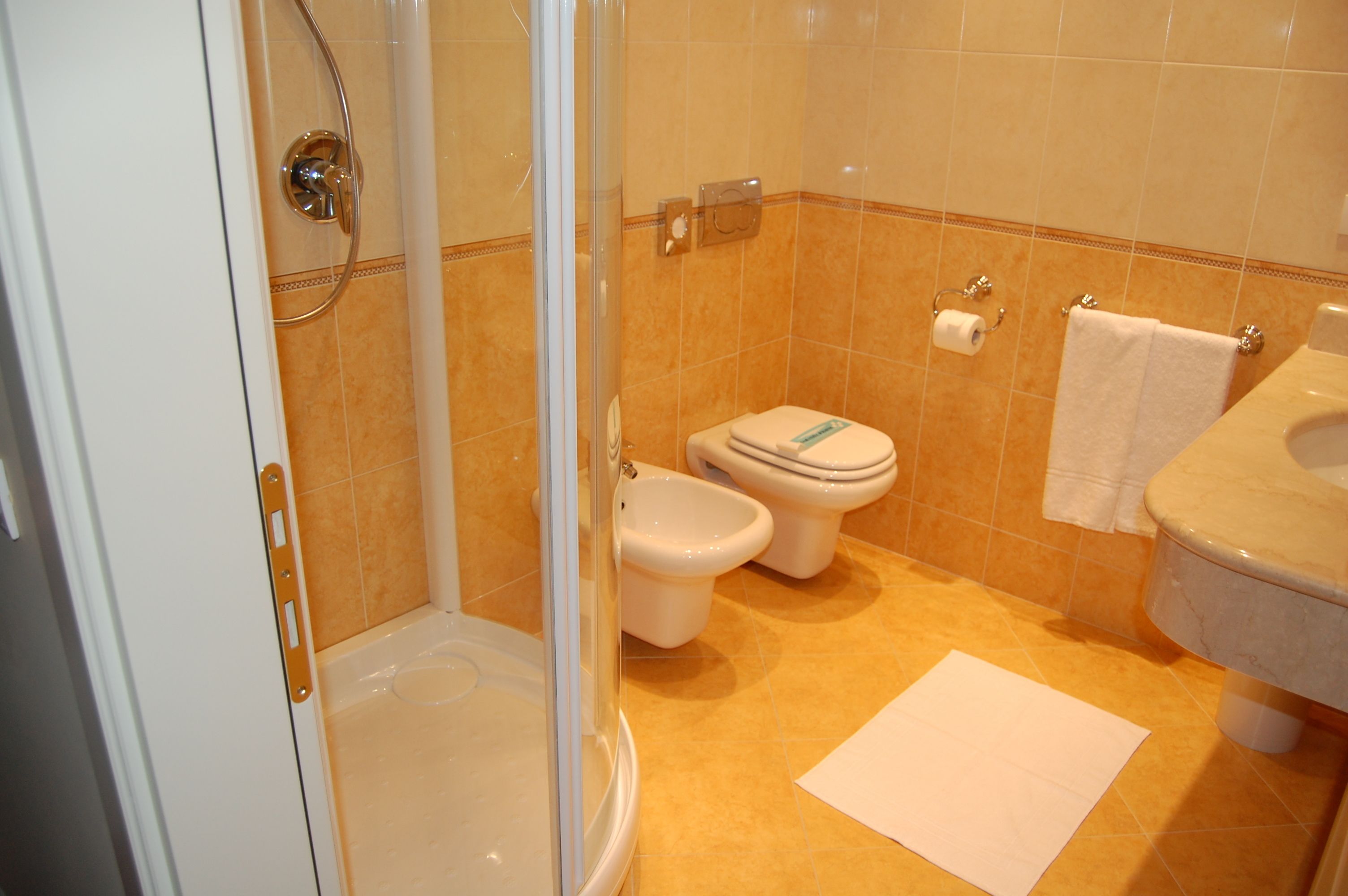 A bathroom with a shower, toilet, and sink.