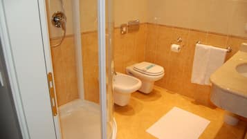 A bathroom with a shower, toilet, and sink.