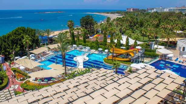 Resort com várias piscinas, um tobogã e vista para a praia.