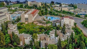 A resort with multiple buildings, a swimming pool, and a large lawn area.