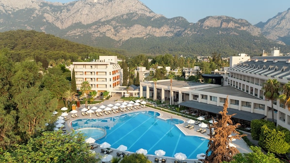 Relax by the resort's large pool surrounded by lush greenery and mountains.