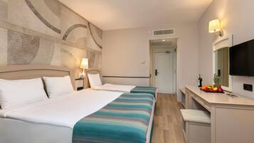 Een hotelkamer met een bed, nachtkastje, lamp en televisie.