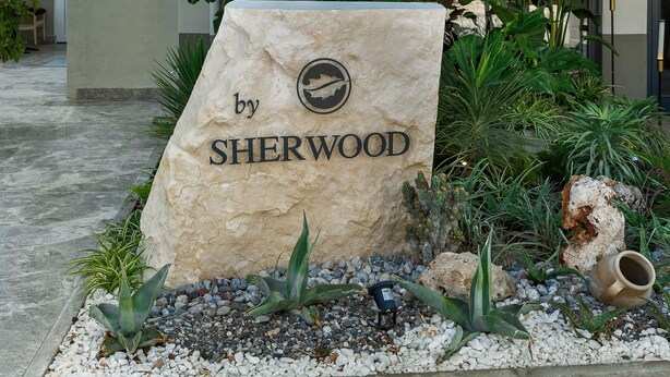 Ein Hotel Eingang mit einem Schild, auf dem 'PREMIO by SHERWOOD' steht.