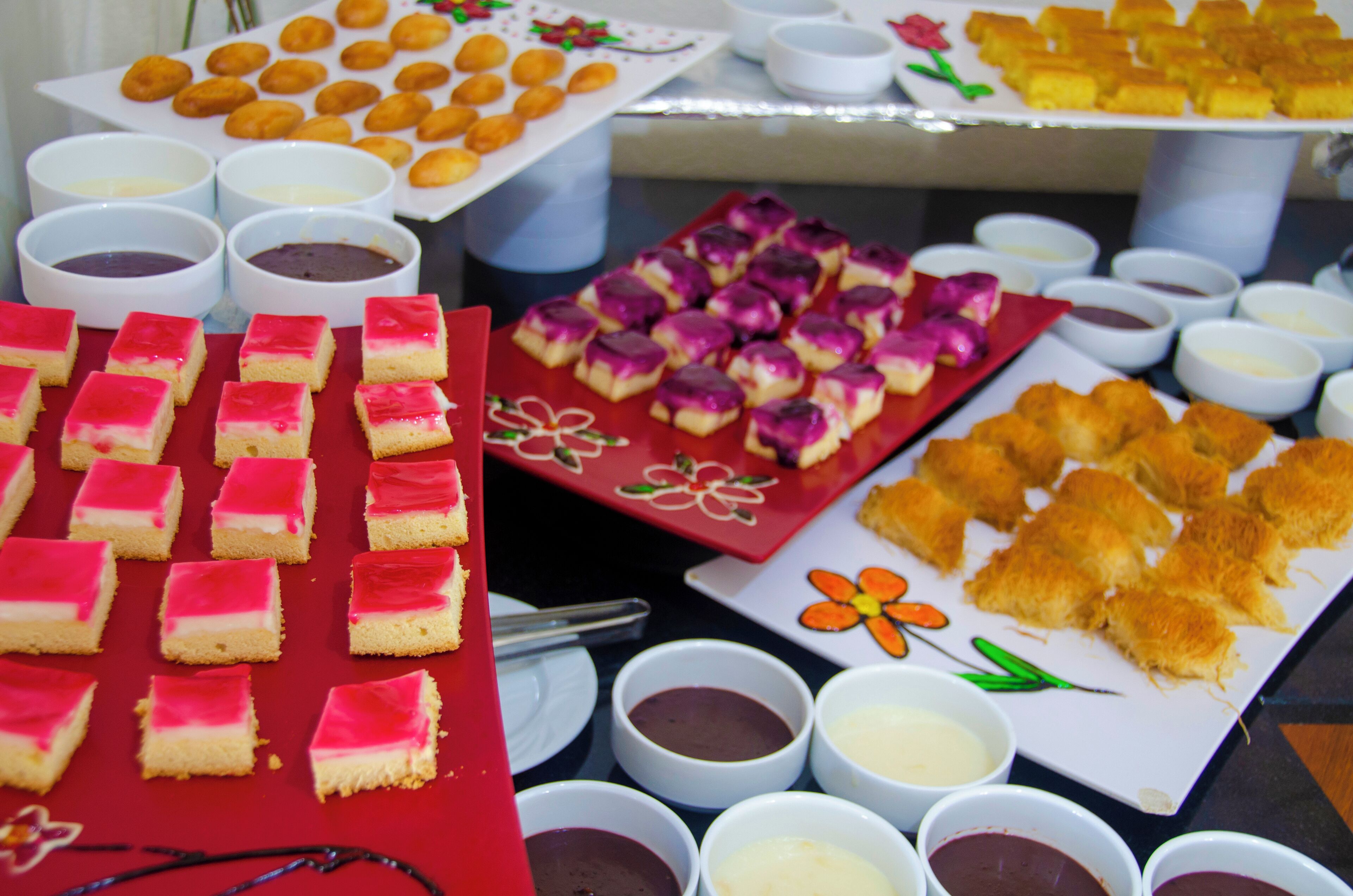 Una mesa de buffet con diversos postres y salsas.