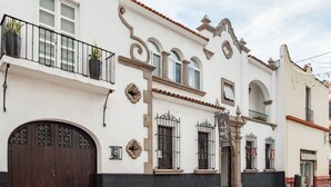 A traditional building with a white facade, black and beige trim, and decorative ironwork. - Quinta Allende (Querétaro)