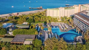 Ein Resort mit mehreren Swimmingpools, einer Strandbereiches und einem großen Gebäude mit Balkonen.