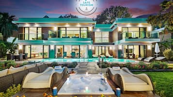 Relax in our outdoor area with a hot tub and comfortable seating, surrounded by a lush garden and scenic views.