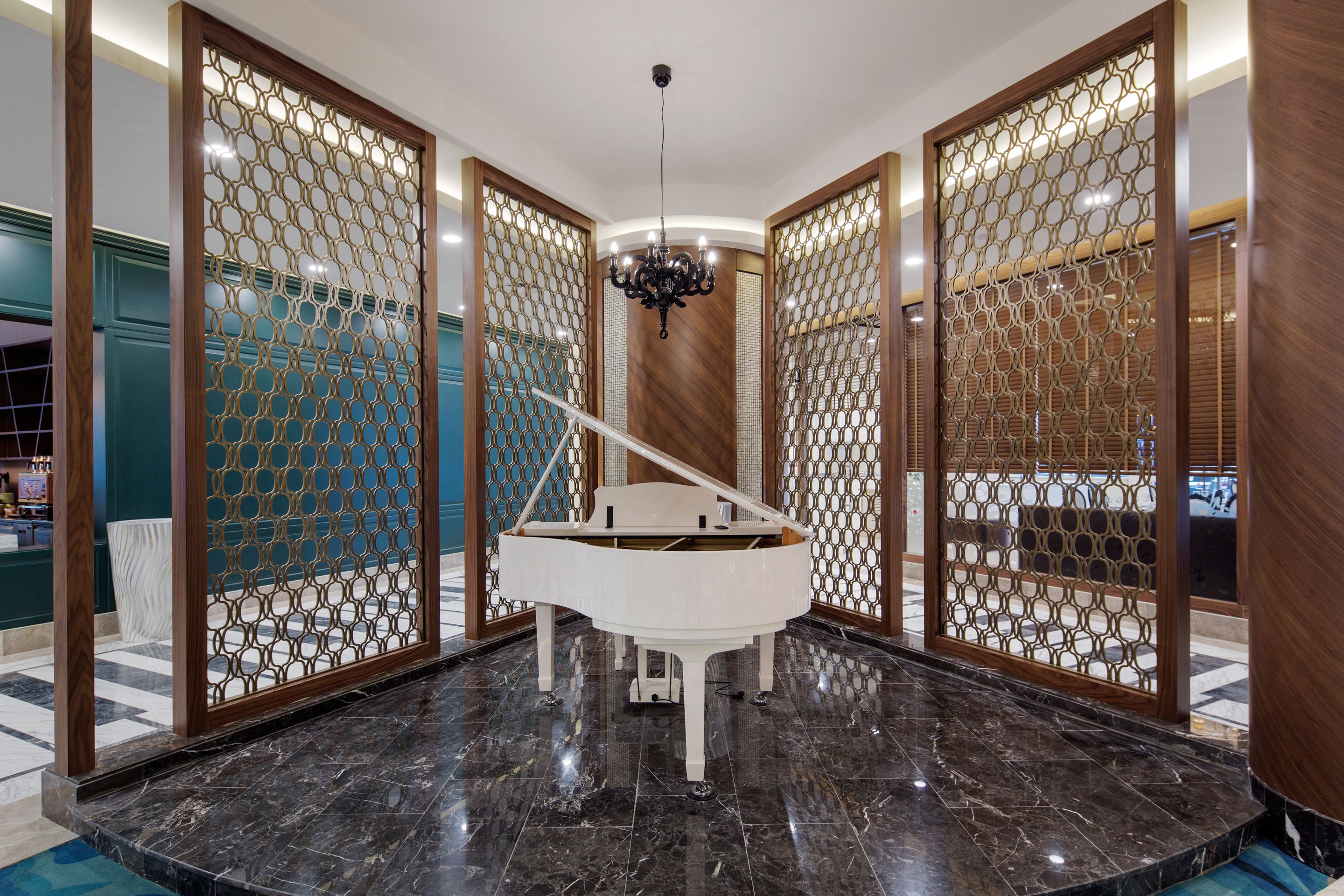 A grand piano in a spacious room with a marble floor, surrounded by decorative wooden screens.