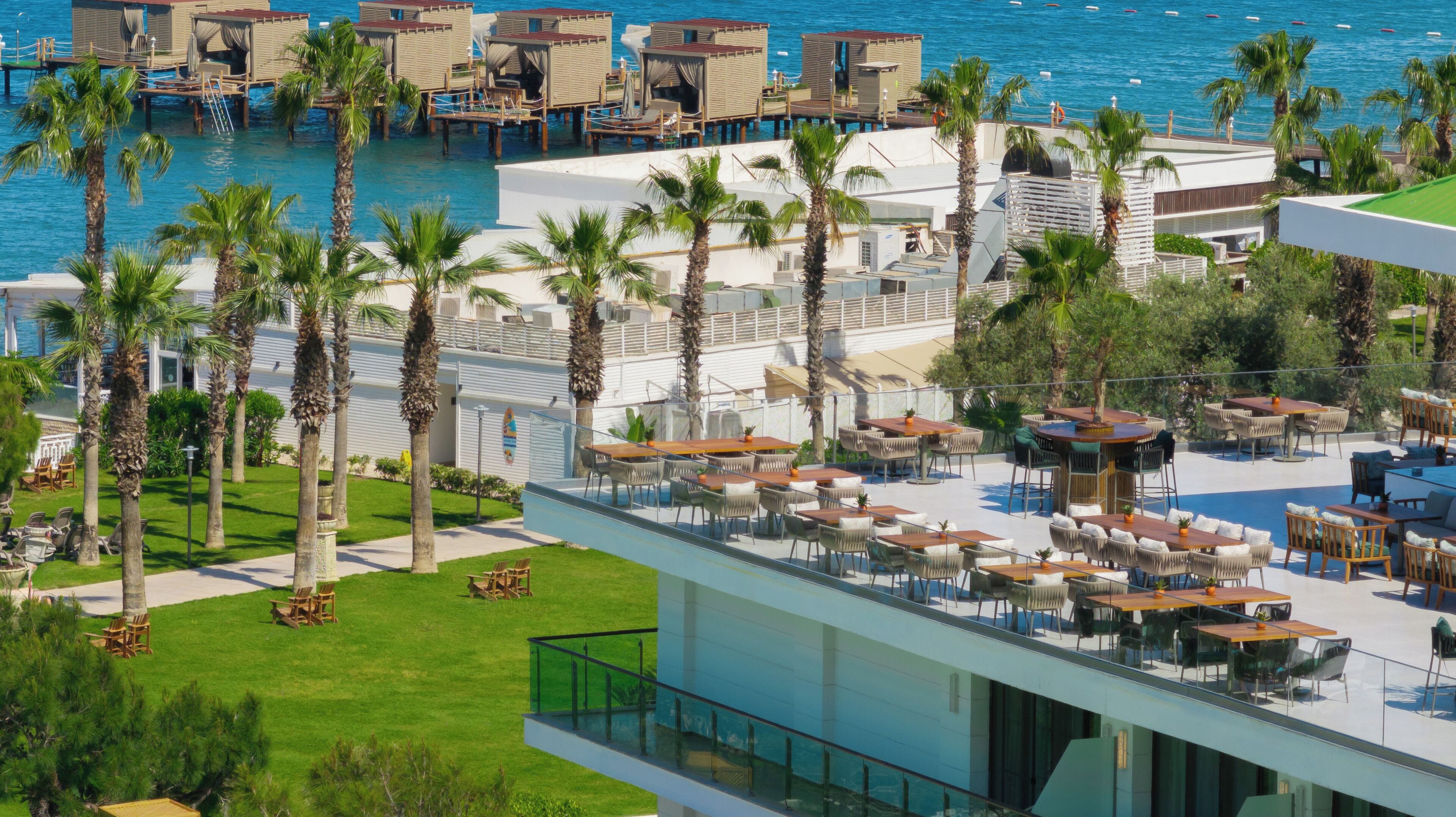 A resort with overwater bungalows, outdoor dining areas, and a pool.