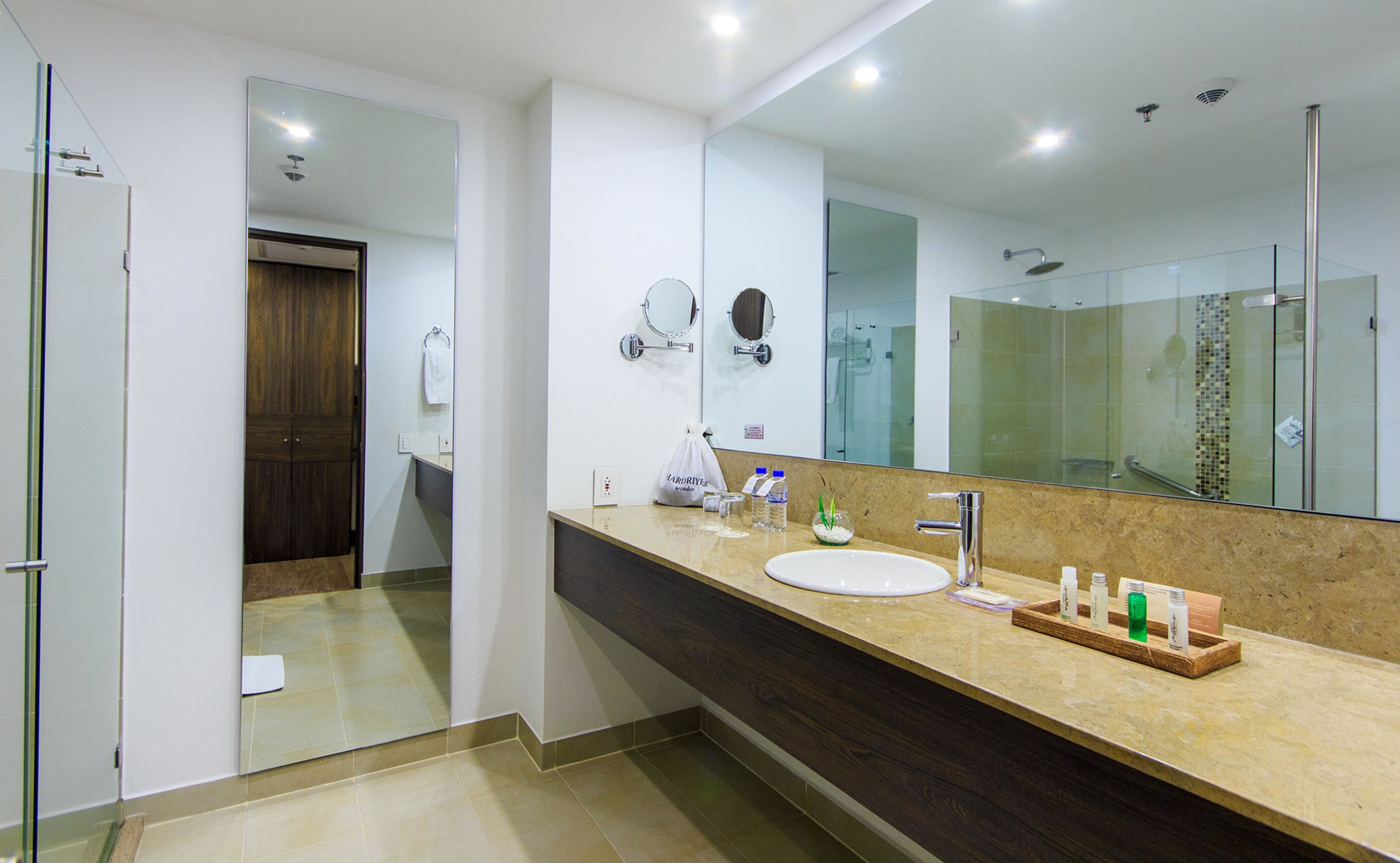 A modern bathroom with a large mirror, a sink, and a shower area.