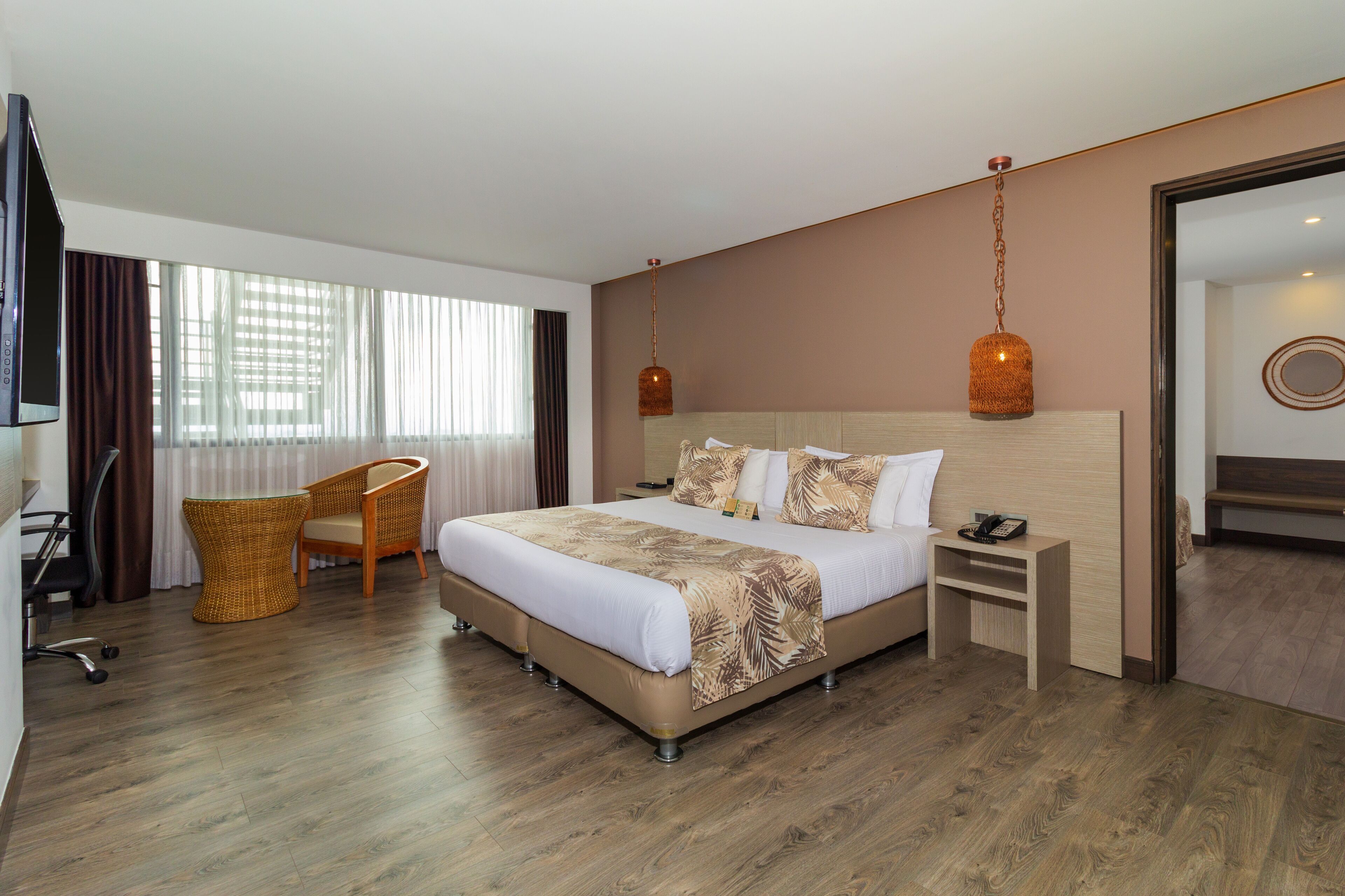 Una habitación de hotel moderna con una cama grande, un escritorio y una silla.