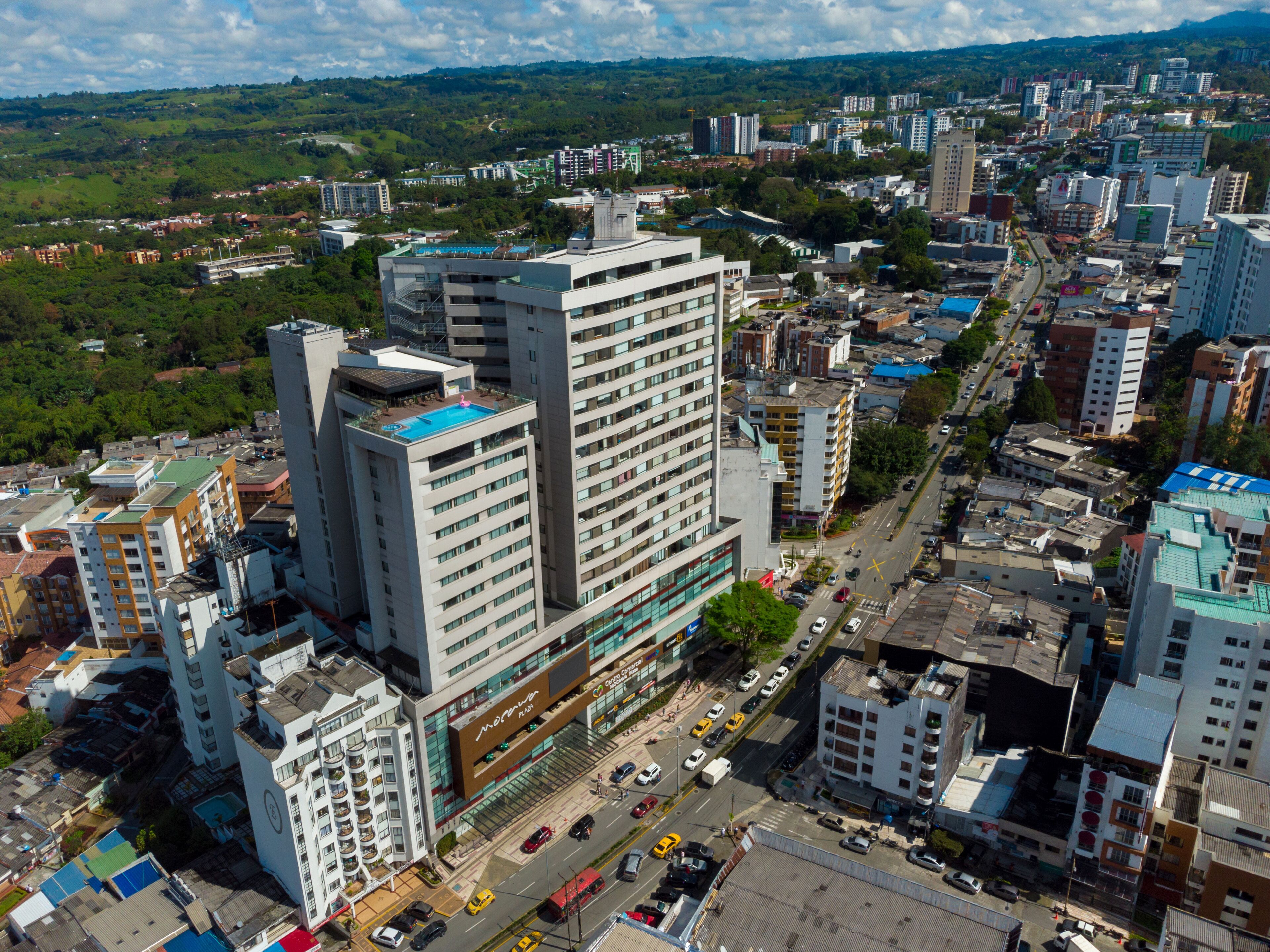 A high-rise hotel with multiple floors, a rooftop pool, and a central courtyard.