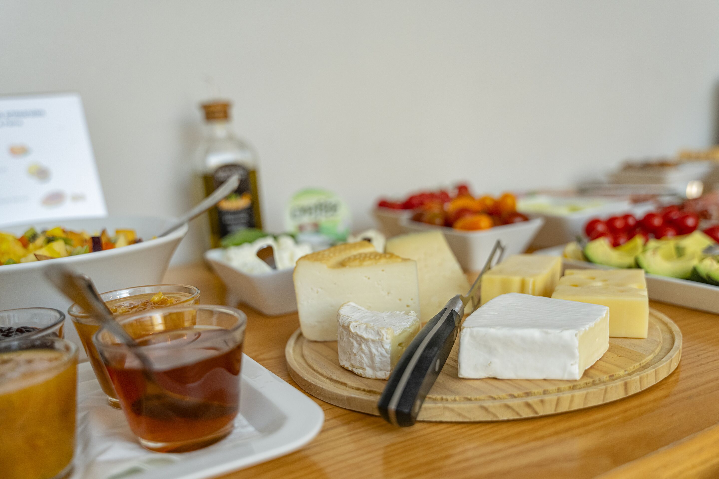 A cheese board with various cheeses and fruits.