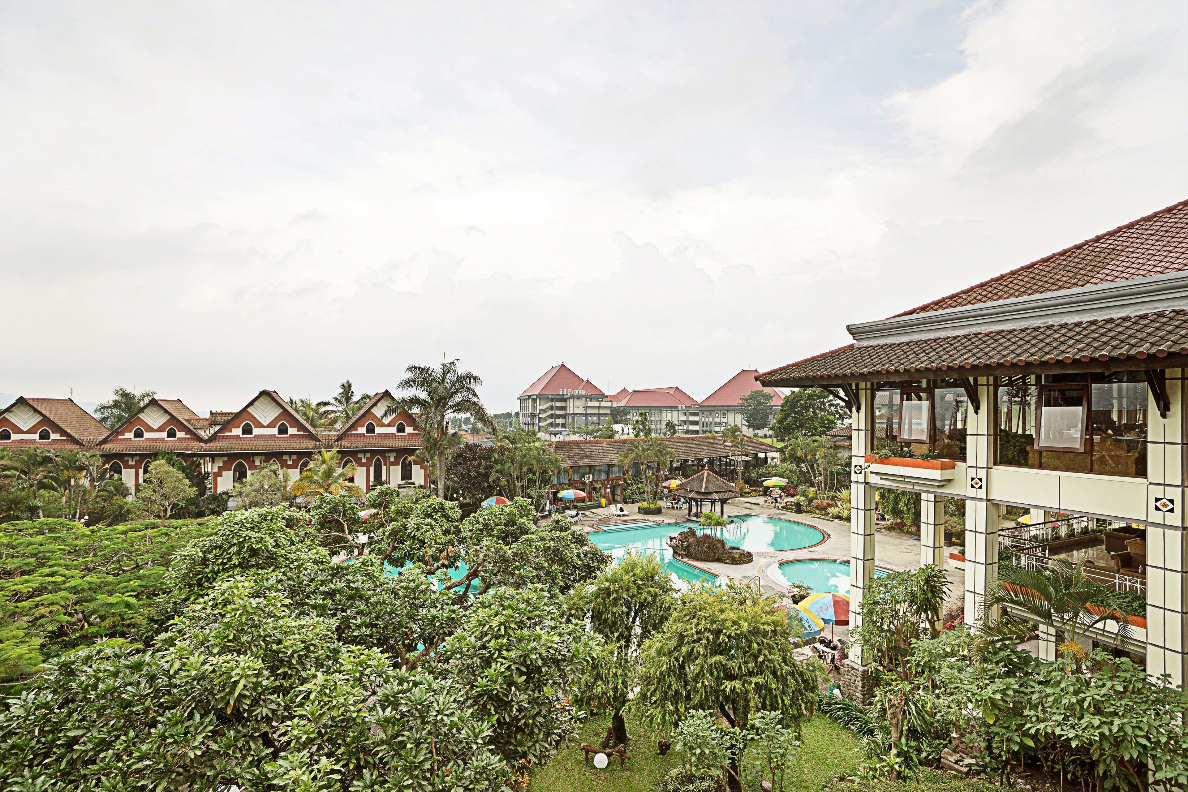 A resort with multiple villas, a central pool area, and lush greenery.