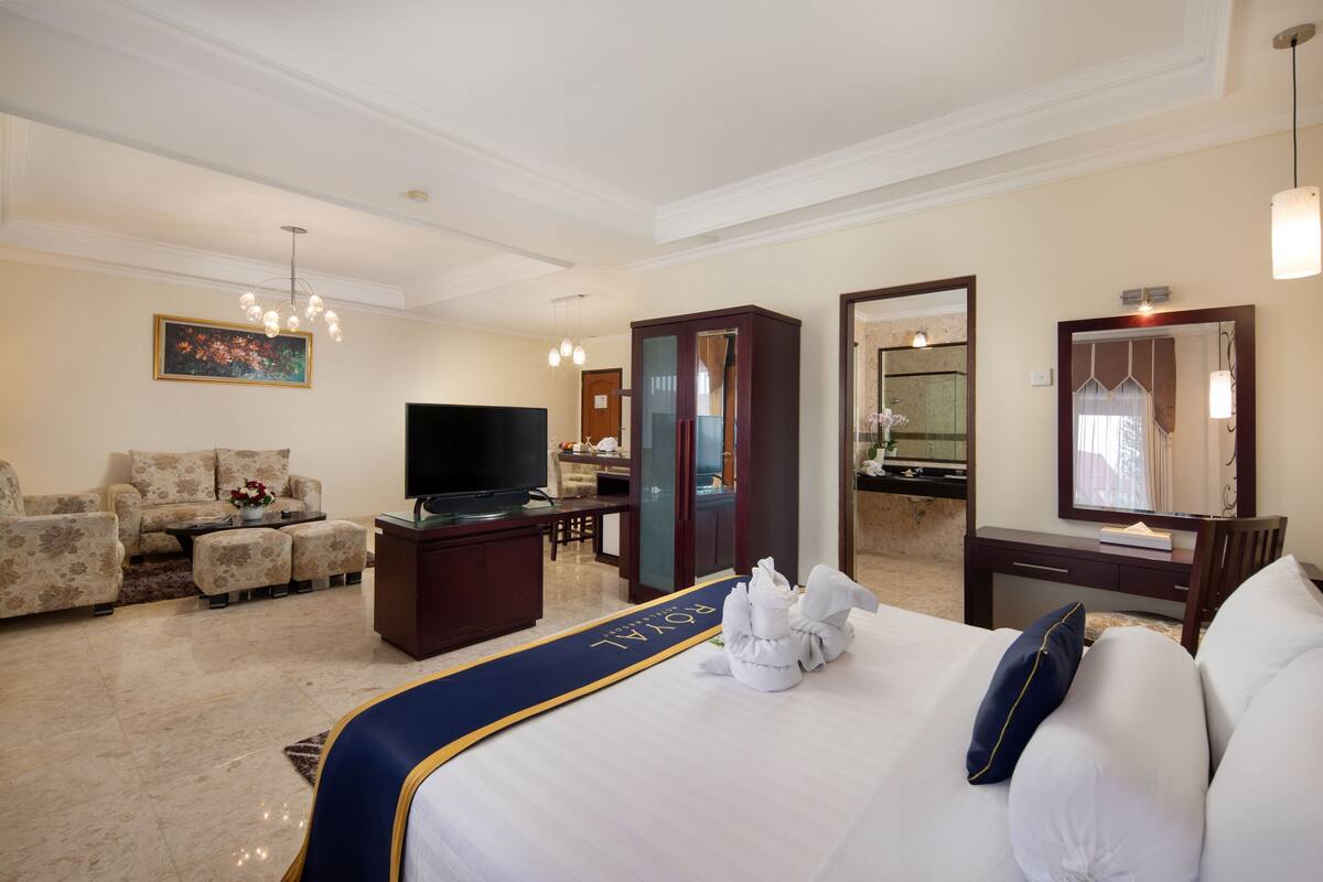 Une chambre d’hôtel avec un grand lit, une télévision, un bureau et un canapé.