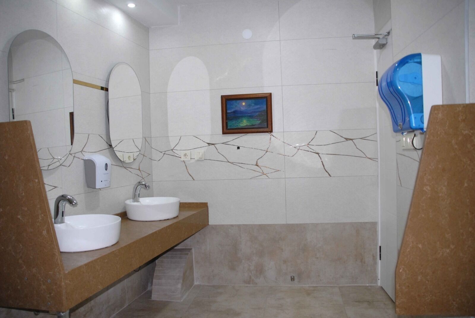 Un baño moderno con dos lavabos, un espejo grande y una zona de ducha.