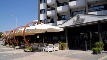 Un hotel con mesas al aire libre y un letrero que dice "Sunway".