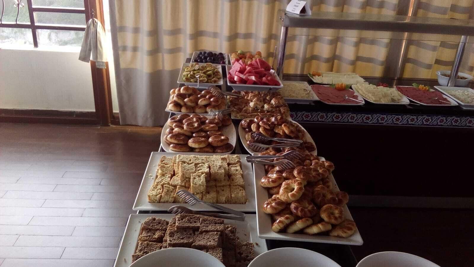 A buffet with various food items including pastries, meats, and fruits.