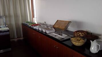 Un buffet con diversi cibi e una postazione per il caffè.