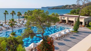 A pool area with lounge chairs and umbrellas, a building labeled "MARE", and a view of the sea. - Sherwood Exclusive Kemer (Kemer)