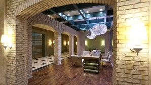 Un interior moderno con paredes de ladrillo, suelo de madera y una zona de estar central con una mesa y sillas.