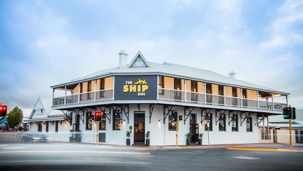 Un bâtiment à deux étages doté d’un balcon et d’une enseigne indiquant « The Ship Inn ».