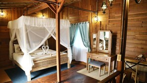 Una habitación de madera con una cama, un escritorio y un espejo.