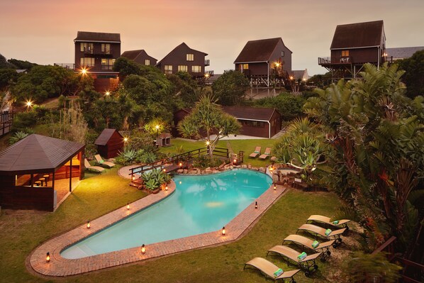 Una piscina al aire libre, sillones reclinables de piscina